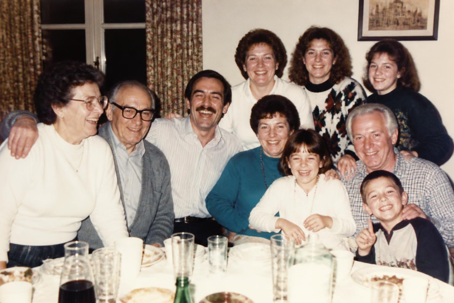 A 1980s family gathering photograph, three generations around a table